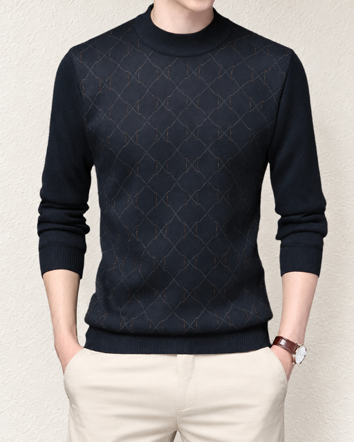 Dark patterned long-sleeve top worn against an ivory wall.
