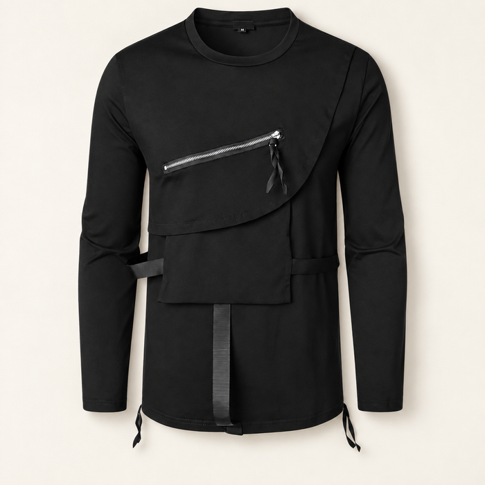 Black asymmetric long-sleeve shirt with layered panels, a diagonal zipper and straps on an ivory surface.