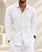 White long-sleeve shirt with an open collar and curved hem, worn in a softly lit ivory interior.
