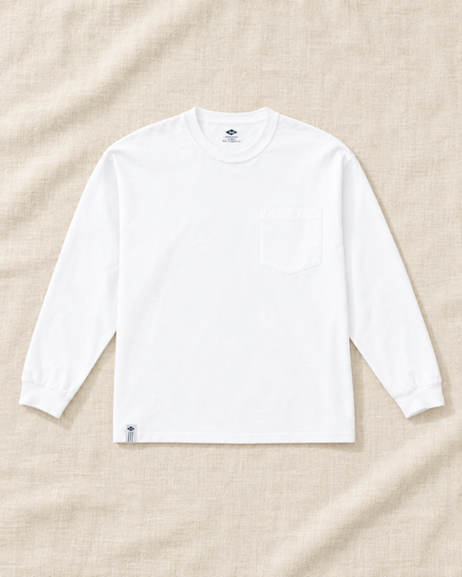 White long-sleeve crew-neck shirt with a chest pocket laid flat on ivory linen.