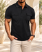 Black short-sleeve polo with two chest pockets in an ivory courtyard.