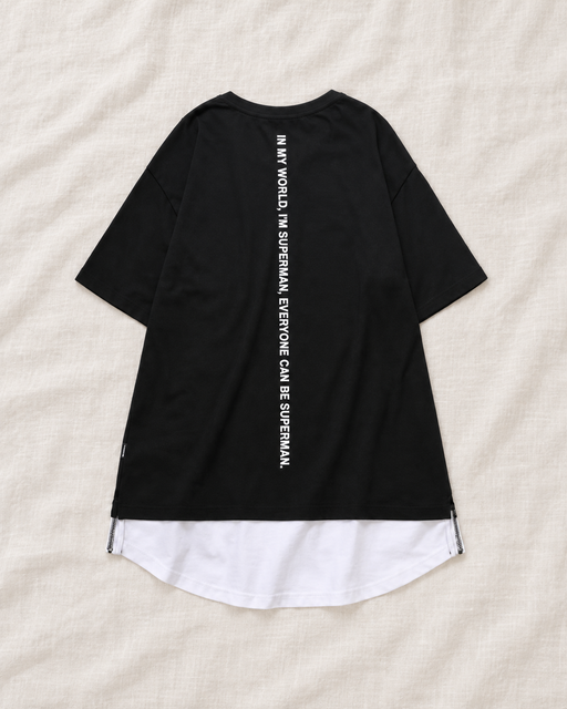 Back of a black short-sleeve T-shirt with vertical white lettering and a curved white layered hem.