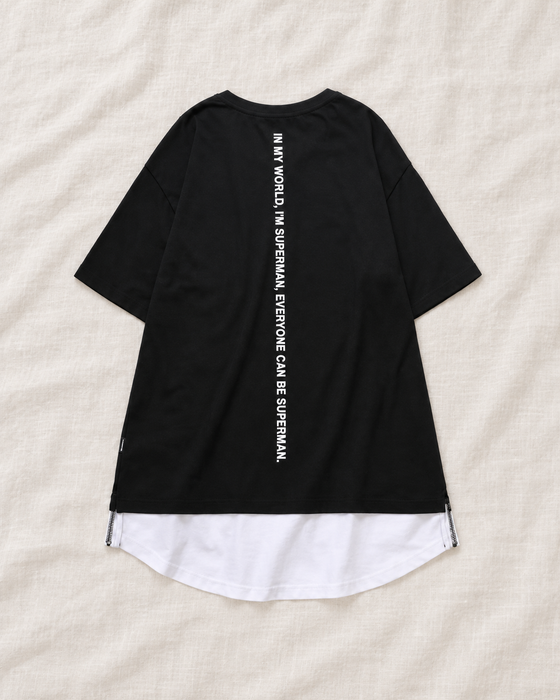 Back of a black short-sleeve T-shirt with vertical white lettering and a curved white layered hem.
