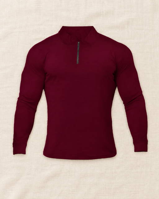 Burgundy quarter-zip long-sleeve top on an ivory surface.