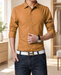 Ochre long-sleeve dress shirt with rolled cuffs worn in a softly lit dressing room.