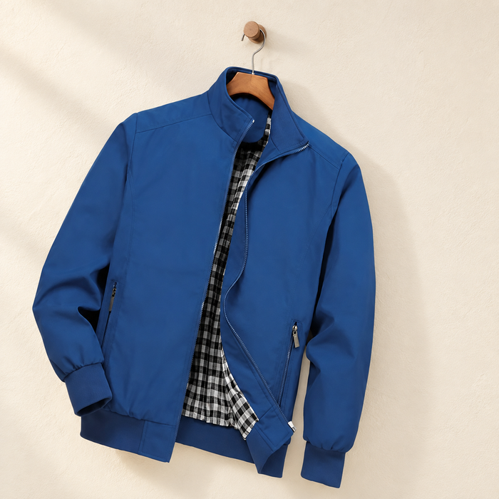 Blue zip jacket with checked lining on a wooden hanger against an ivory wall