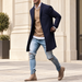 Man wearing navy long coat beside an ivory stone facade.