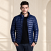 Man wearing an open navy quilted jacket in an ivory dressing room.