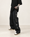 Loose black jeans with six visible silver side buttons in an ivory interior.