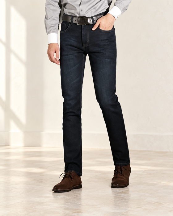 Dark indigo straight-leg jeans worn with brown shoes.