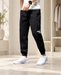 Black tapered trousers with elastic ankle cuffs and white leg lettering.