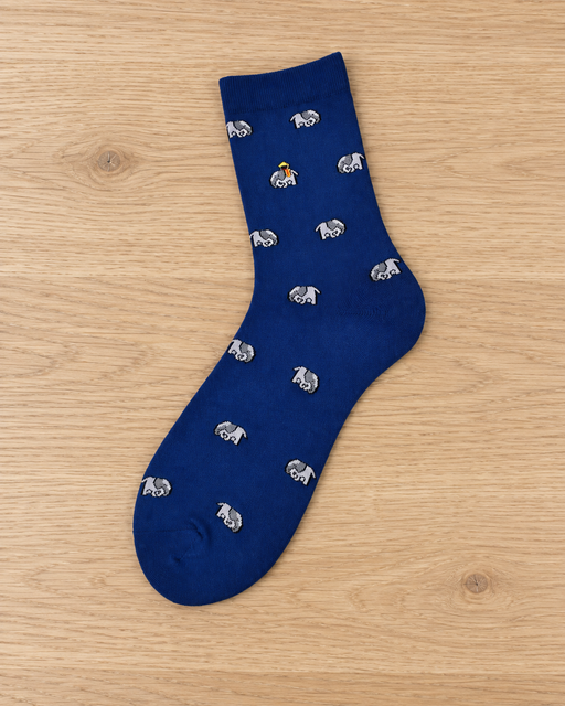 Single blue crew sock with grey elephant motifs laid on a pale wooden bench.