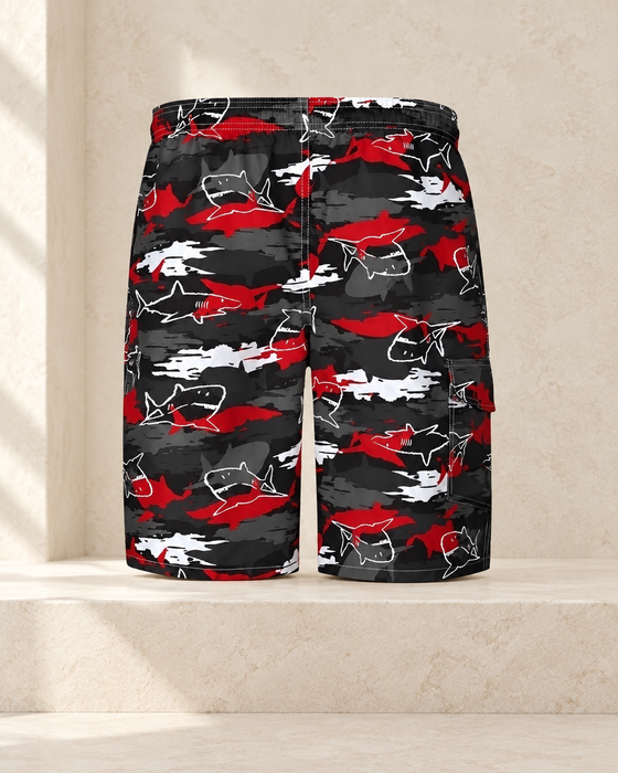 Black, red and white shark-print shorts displayed against pale stone.