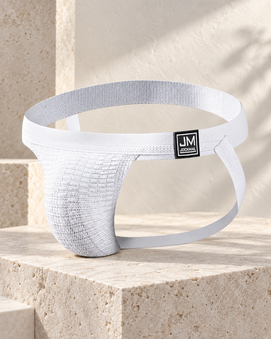 White athletic support garment with a JM JOCKMAIL label displayed on pale limestone.