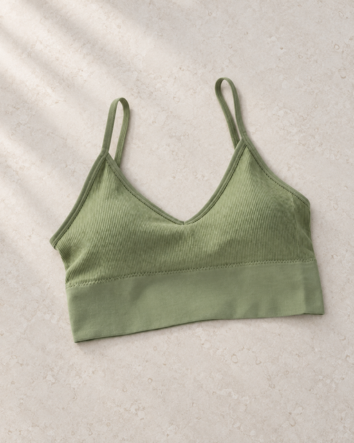 Olive green ribbed cropped camisole with thin straps laid on a pale stone surface.
