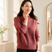 Dusty rose cable-knit high-neck sweater worn in an ivory dressing room.