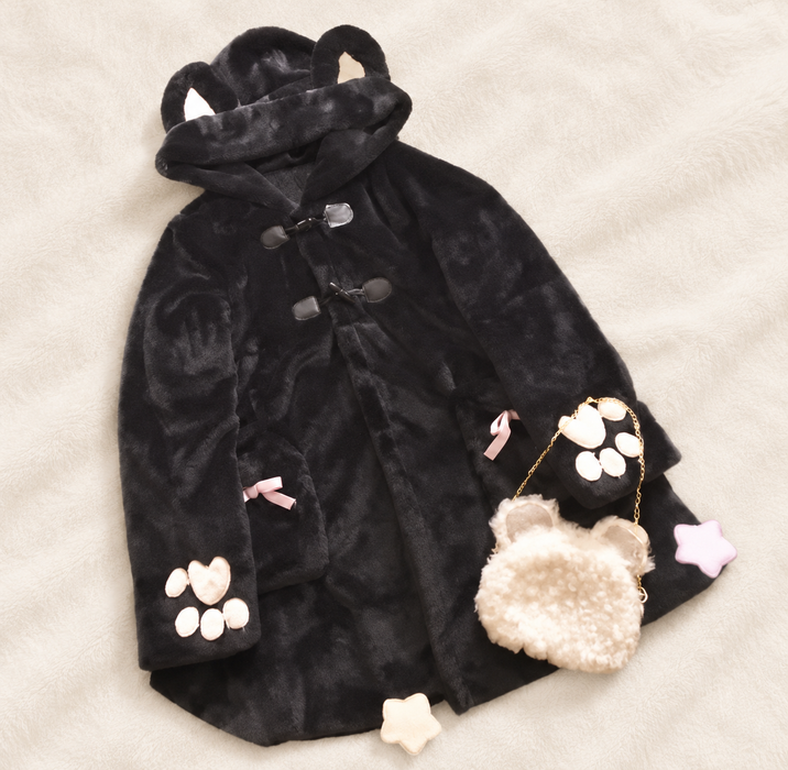 Black hooded coat with paw appliques and pink bows beside a small bear bag and pastel stars