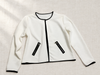 Ivory jacket with black trim and two zip pockets on linen