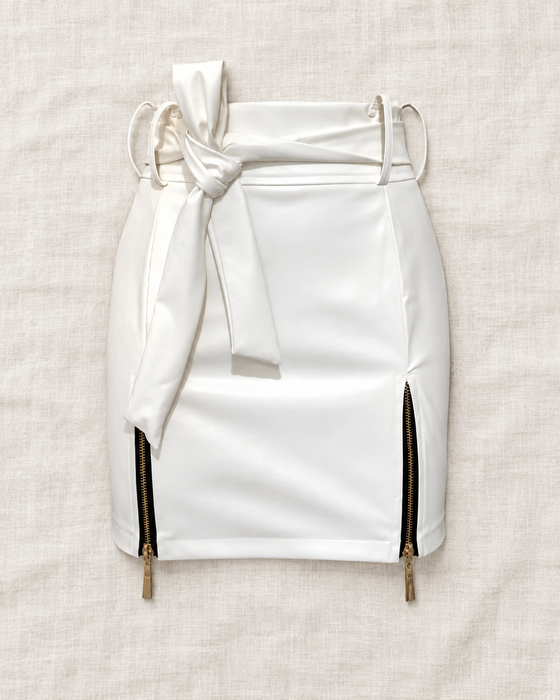 White mini skirt with a self-tie waist and two gold-tone side zippers on ivory linen.