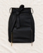 Black mini skirt with a self-tie waist and two gold-tone side zippers on ivory linen.