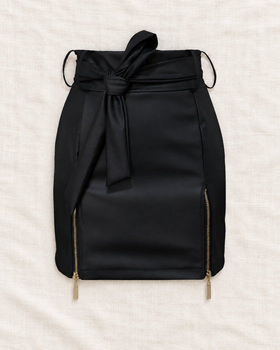 Black mini skirt with a self-tie waist and two gold-tone side zippers on ivory linen.