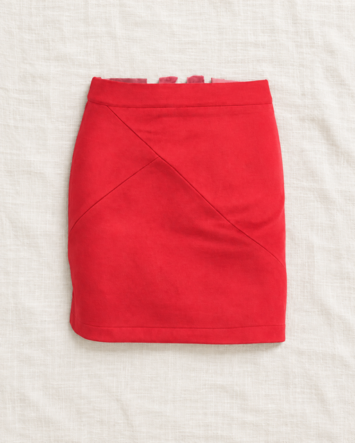 Red short skirt with diagonal front seams on ivory linen.