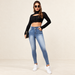 Blue high-waisted jeans with faded front panels worn in an ivory studio