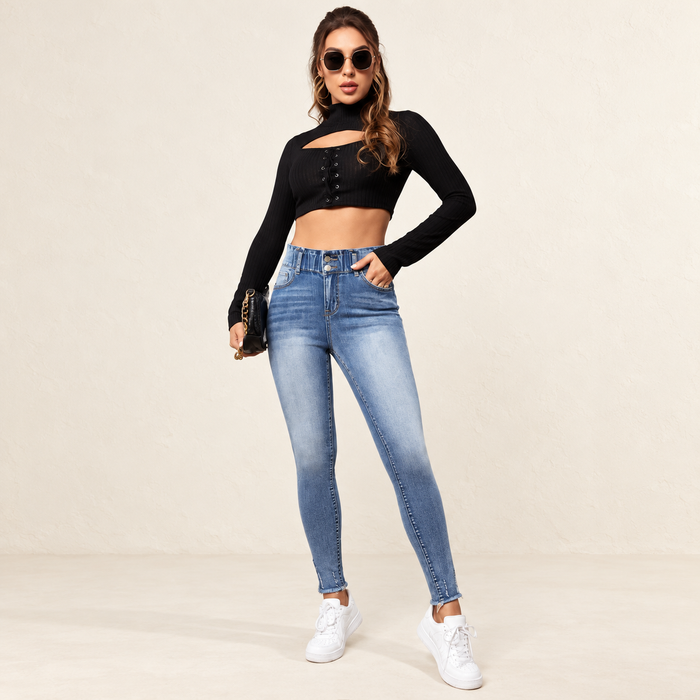 Blue high-waisted jeans with faded front panels worn in an ivory studio