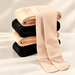 Stack of beige and black warm leggings with beige feet draped in front