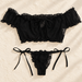 Black ruffled two-piece set displayed on an ivory surface