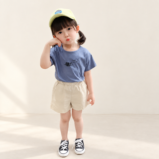 Dusty blue bee-print top and cream shorts in an ivory studio
