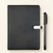 Black notebook and pen on ivory surface