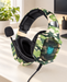 Army green camouflage headphones with a foam-tipped microphone on an ivory desktop.