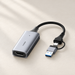 Silver video capture adapter with USB connectors on an ivory surface