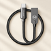 Black braided cable with its original connector housings on a warm ivory desk.