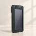 Black solar power bank with green accents on a warm neutral surface.