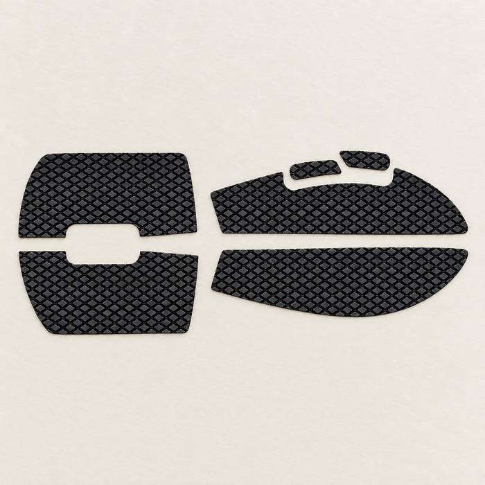 Six black textured mouse grip stickers on an ivory desk
