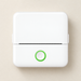 White thermal printer with green power button on an ivory desk
