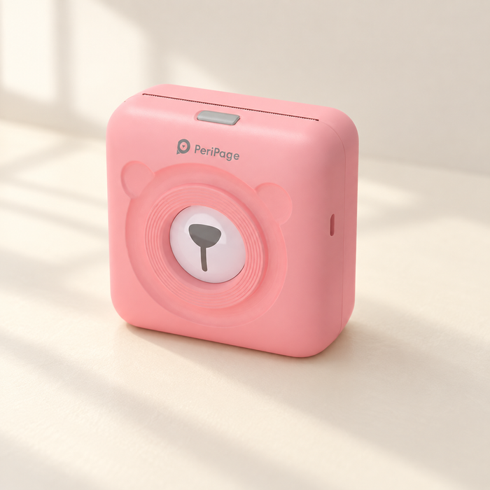 Pink PeriPage mini printer on an ivory desk