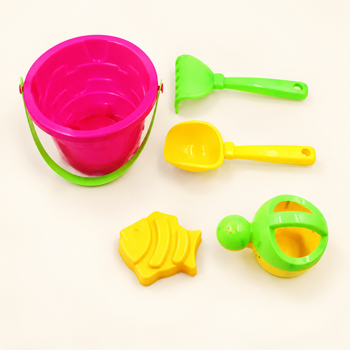 Five brightly coloured beach toys on ivory background