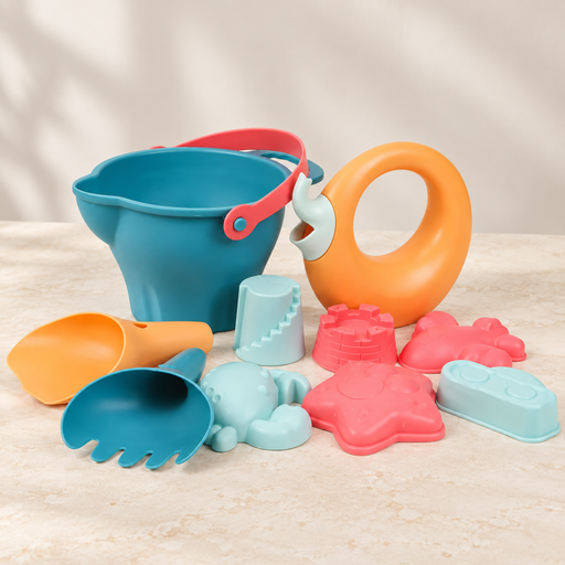 Ten-piece beach toy set with a teal bucket, orange watering vessel and colourful moulds on a light tabletop