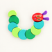 Articulated wooden caterpillar toy arranged in a curve on ivory surface
