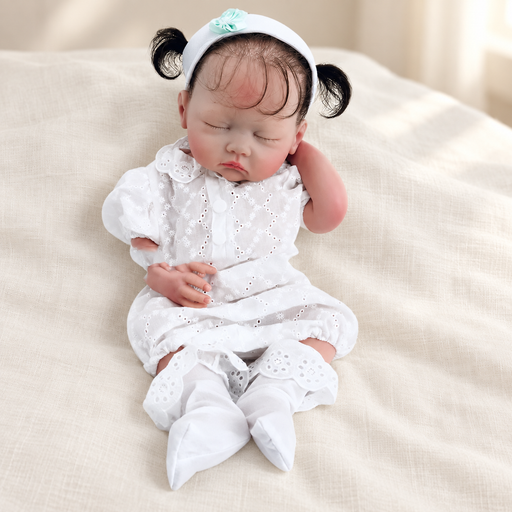 Sleeping doll in a white outfit on ivory linen
