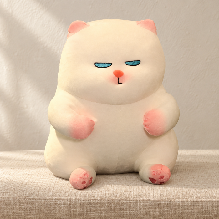 Cream cat plush seated on an ivory linen bench