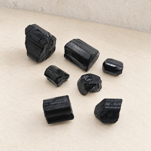 Seven black stone pieces on an ivory surface
