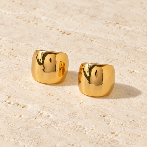 Pair of gold-tone ear clips on warm ivory stone