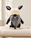 Black plush dog toy with a cream hat and grey beard on an ivory linen bench.