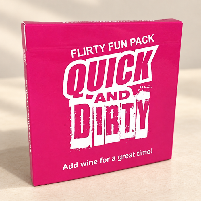 Pink Quick and Dirty card game box on an ivory tabletop.