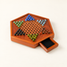 Wooden Chinese checkers board with glass marbles and open drawer on ivory table