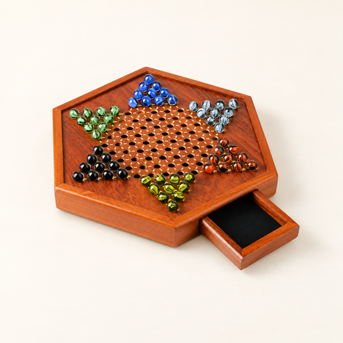 Wooden Chinese checkers board with glass marbles and open drawer on ivory table